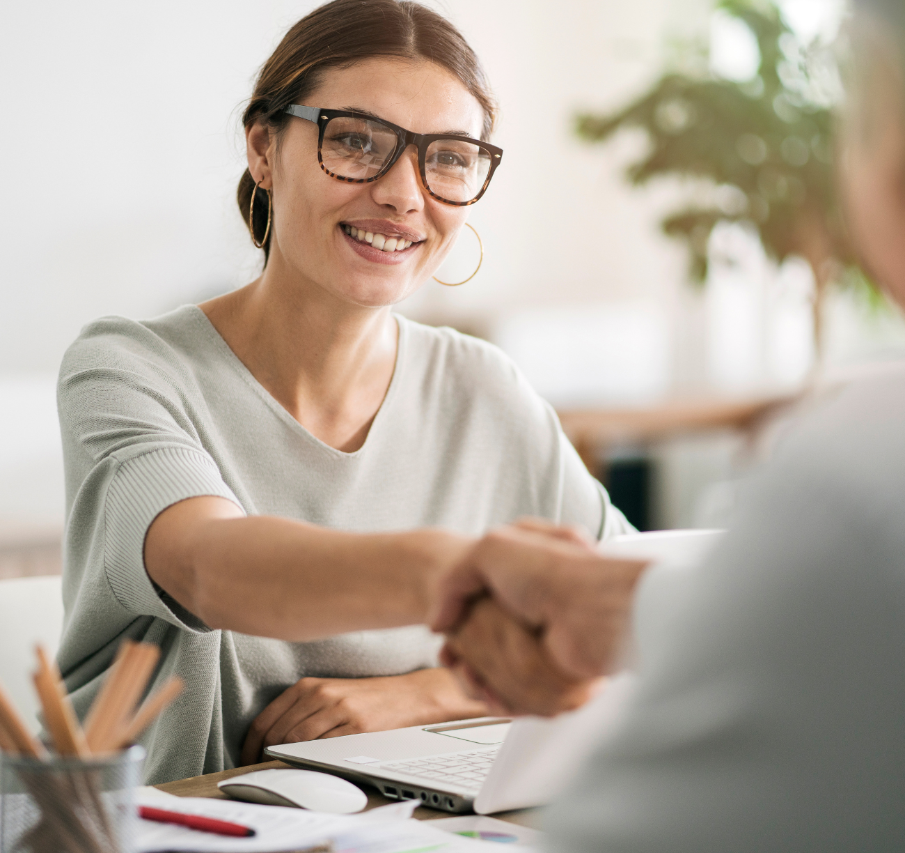 Speak to an Expert Smiling woman shaking hands with advisor during home loan consultation